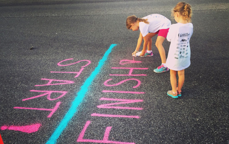 Children drawing a finish line with chalk